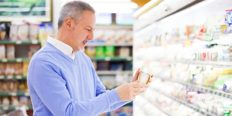 hombre mirando fecha de caducidad a un yogurt